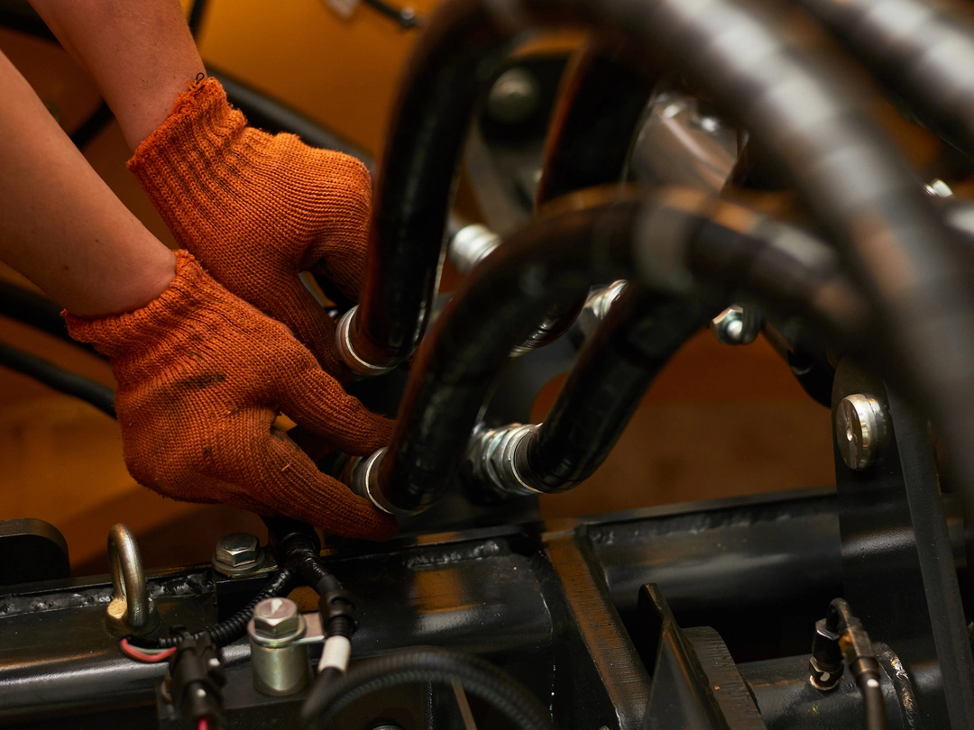 A skilled technician expertly connects hydraulic hoses, ensuring the machinery operates at peak efficiency